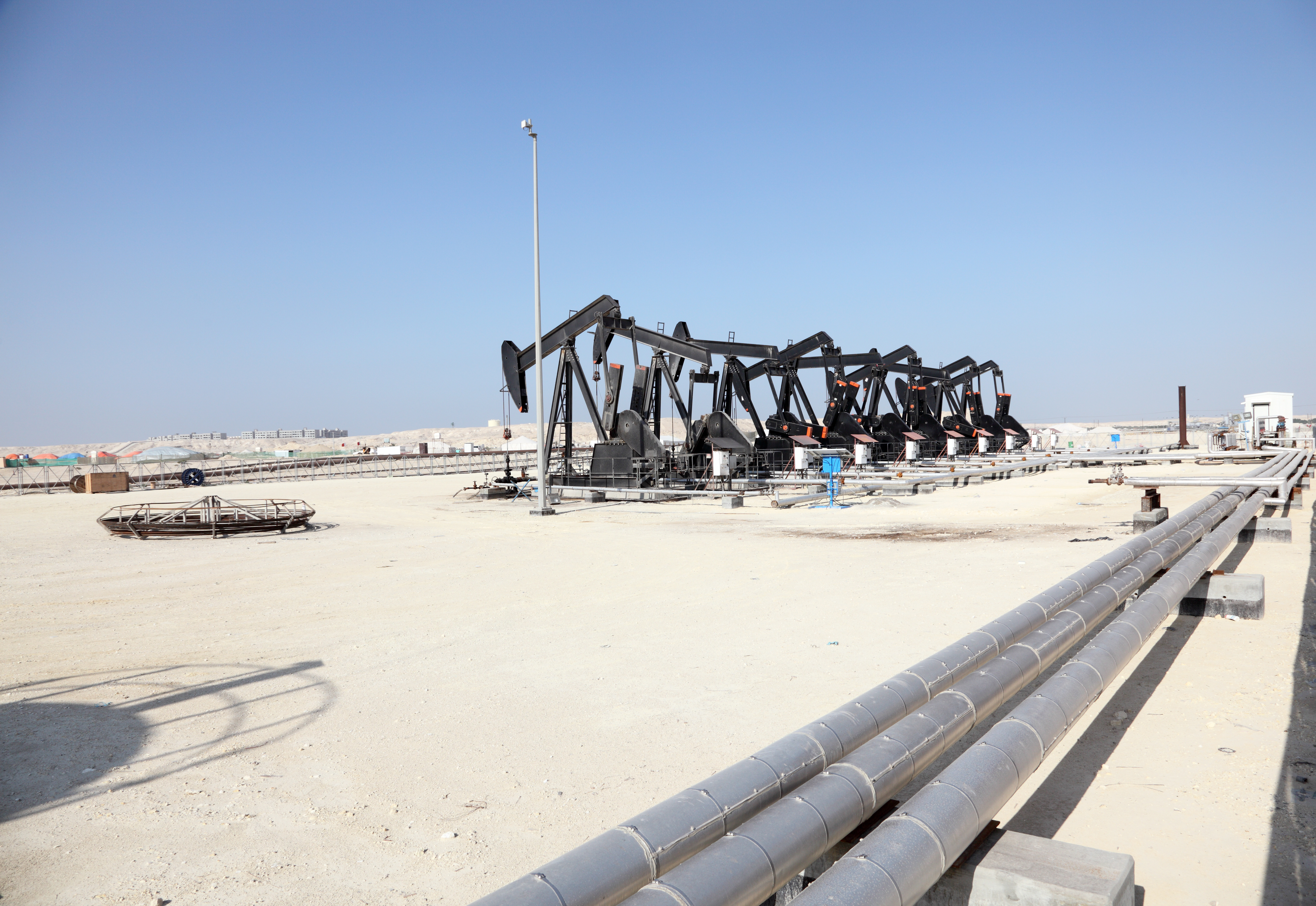 Oil pump jacks in the desert of Bahrain, Middle East. Photo courtesy of Adobe Stock.